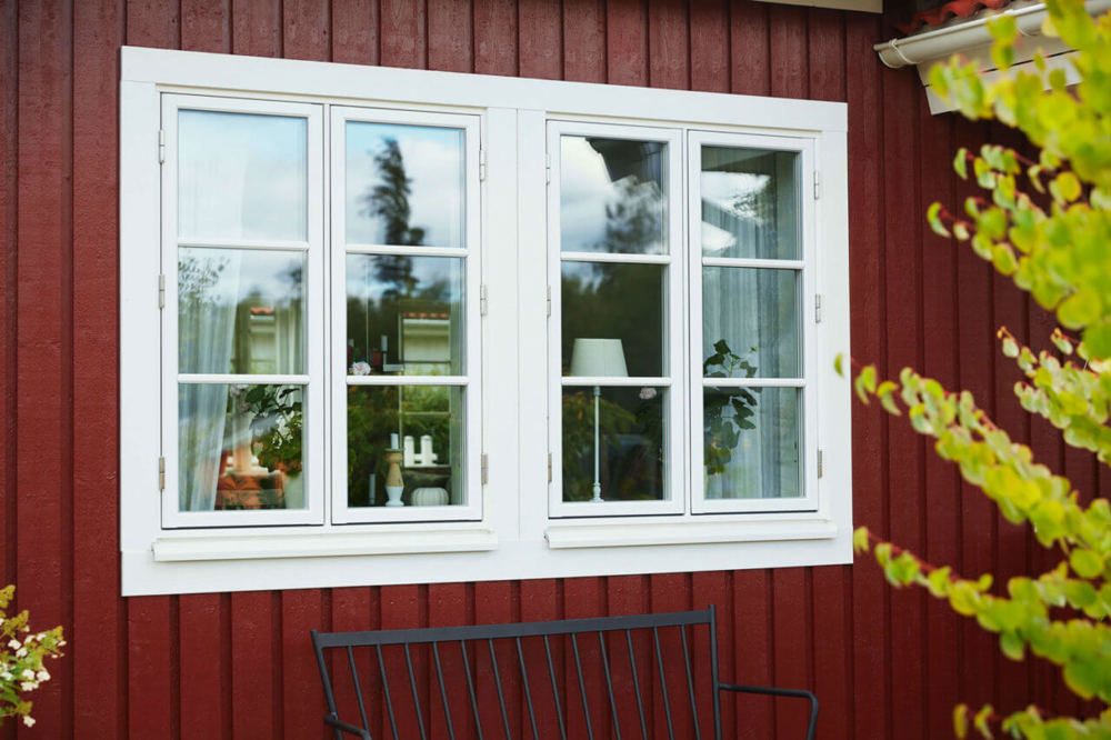 nomenu Bild på ett rött trähus där man ser två fönster sidan om varandra 