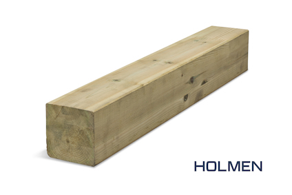 En limträpelare av furu med en fyrkantig form ligger snett mot en vit bakgrund. Texten "HOLMEN" syns i nedre högra hörnet.