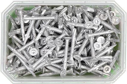 Skruvar i metall i en rektangulär, transparent plastlåda.