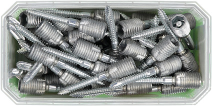 Rektangulär plastbehållare med flera metallplugg och skruvar.