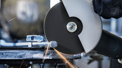 Vinkelslip som skär genom metall, gnistor flyger.