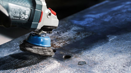 Vinkelslip med stålborste slipar metallplåt.