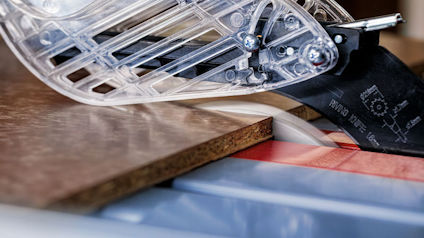 Kakelplatta skärs med såg. Transparent skydd och synlig tandad klinga.