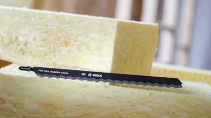 Två isoleringsplattor i mineralull med ett Bosch-sågblad framför sig, etikett synlig.