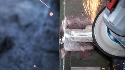 Vinkelslip som slipar metall med gnistor som flyger omkring.