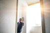 En person applicerar tätning med en caulk pistol på en vägg nära ett fönster med starkt dagsljus.